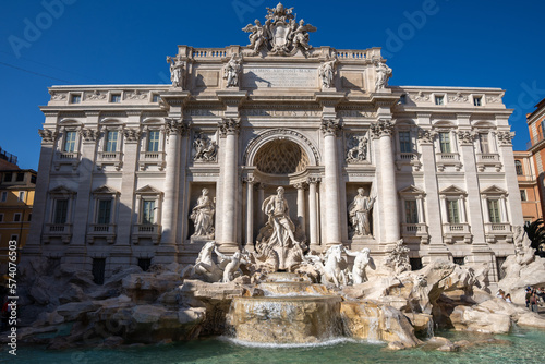 Fontanna di Trevi w Rzymie w słoneczny i bezchmurny dzień. Zasilana wodą z akweduktu rokokowa fontanna z rzeźbami, ukończona w 1762 roku – projekt Nicoli Salviego.