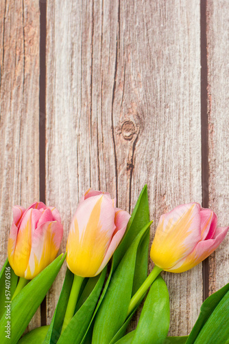 Fototapeta Naklejka Na Ścianę i Meble -  Pink tulips flowers on a wooden background. Copy space.