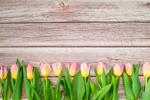 Pink and yellow Tulips Flowers on wooden table for March 8, International Womens Day, Birthday , Valentines Day or Mothers day. Copy space. Bouquet of tulips. Wooden background with copy space.