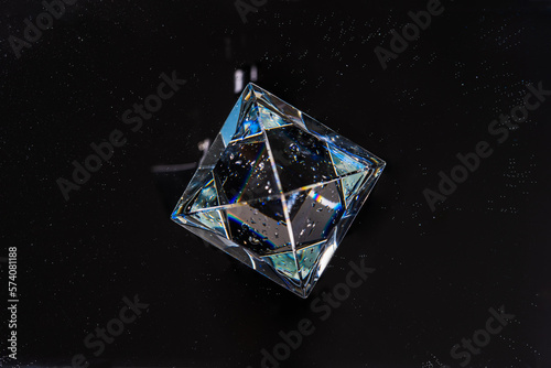 Glass pyramid on an abstract black background of the starry sky, a minimalistic concept of the mystical secrets of outer space and time, the geometric figure of the pyramid, the physics of light