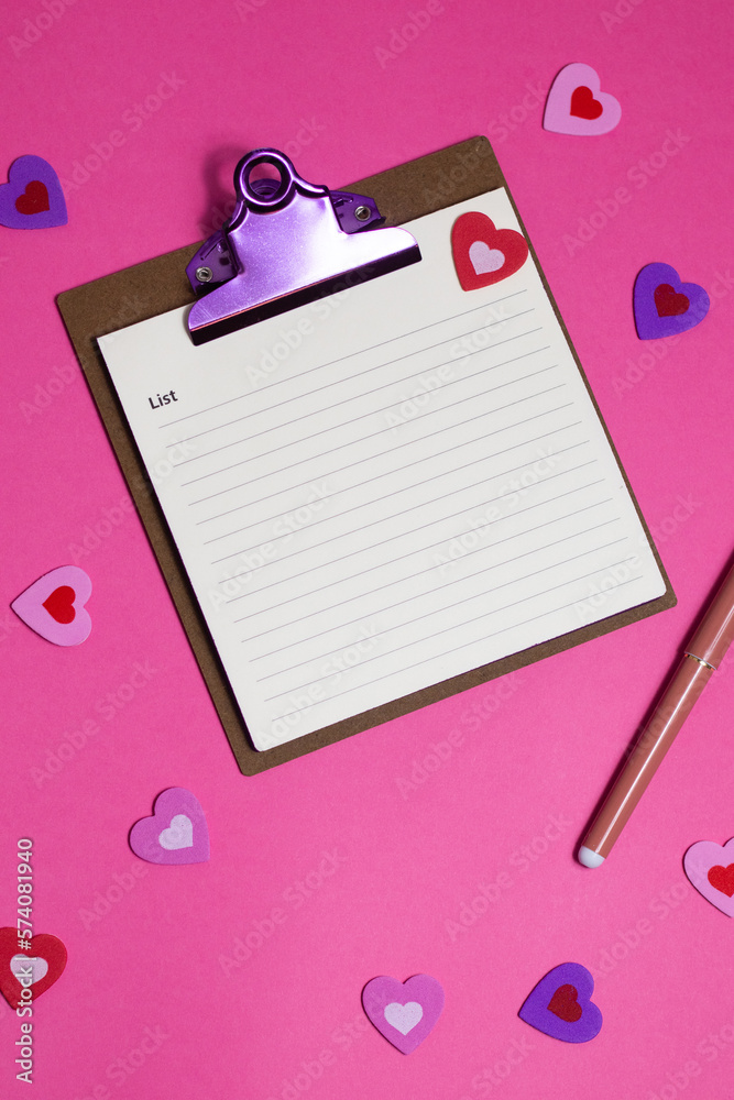 Women's pink office desk. Notepad, pen, stickers on a pink background. Flat lay, top view, copy space, banner Women's pink office desk. Notepad, pen, stickers on a pink background. Flat lay, top view, copy space, banner