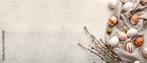 Beautiful Easter eggs and pussy willow branches on light background with space for text