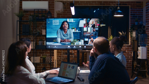 Remote team business meeting, coworkers talking in videocall at night time. Diverse people chatting in teleconference, colleagues brainstorming in videoconference in office zoom in