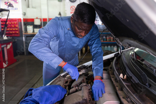 Skilled car mechanician changing filter in vehicle in the auto repair shop
