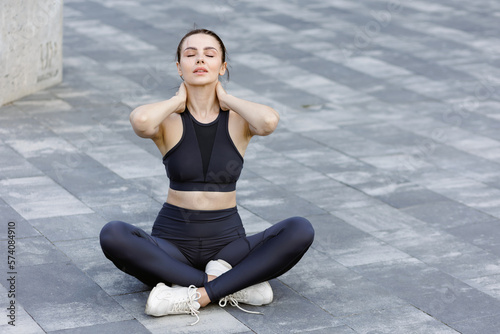 Calm sporty woman with closed eyes breathing, during meditation outdoors. © Tymoshchuk