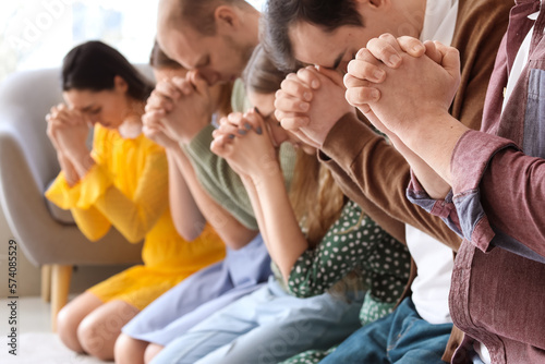 Group of people praying with Holy Bible on floor, closeup