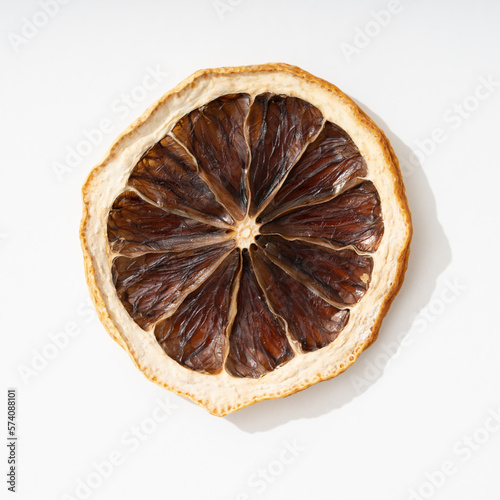Dehydrated lemon slice isolated on white background with strong shadow