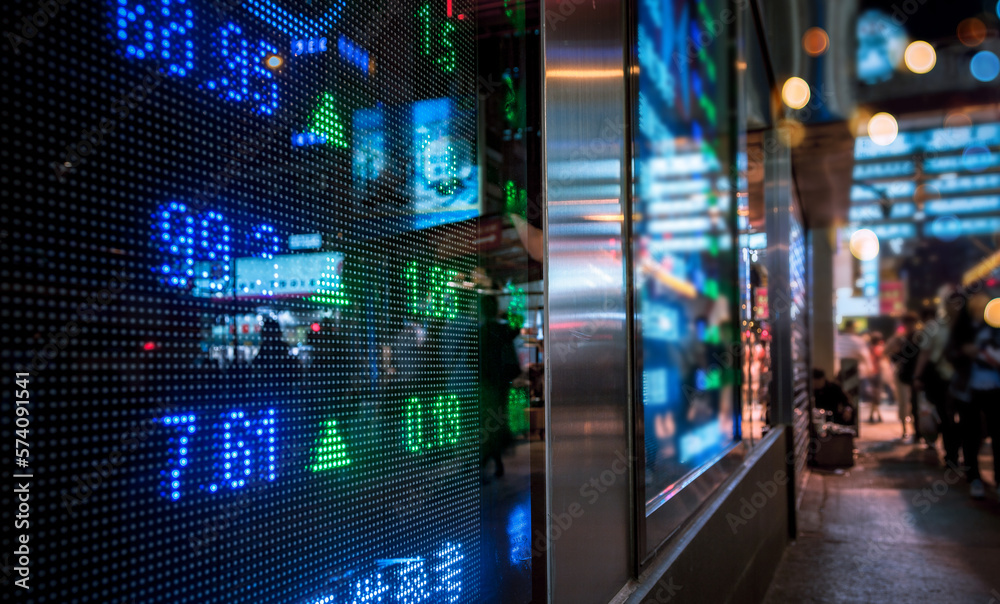 Financial stock exchange market display screen board on the street with and city light reflections, selective focus Financial stock exchange market display screen board on the street with and city light reflections, selective focus