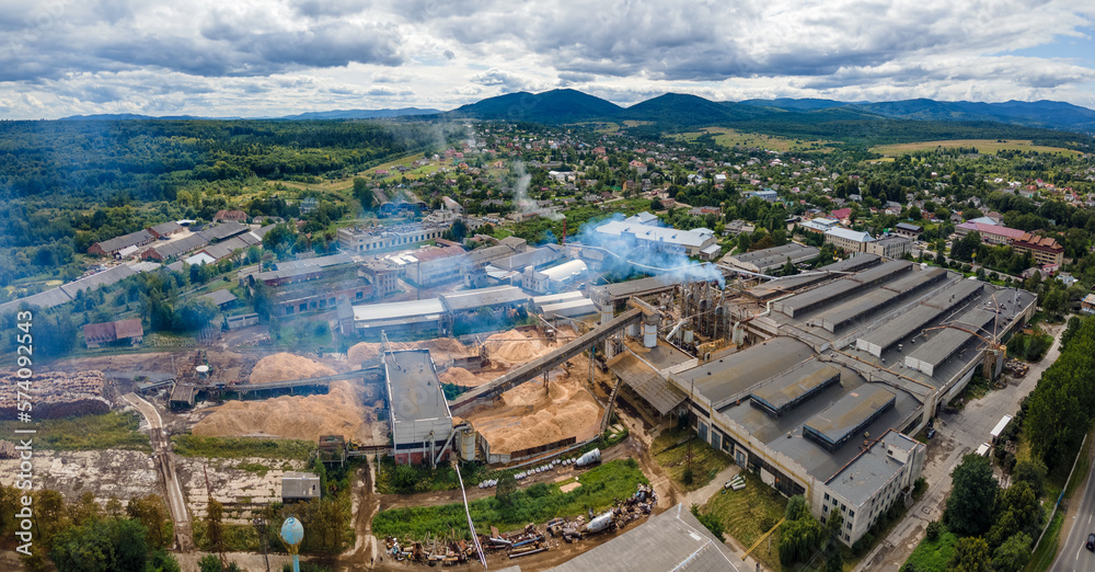 Aerial view of wood processing plant with smokestack from production process polluting environment at factory manufacturing yard