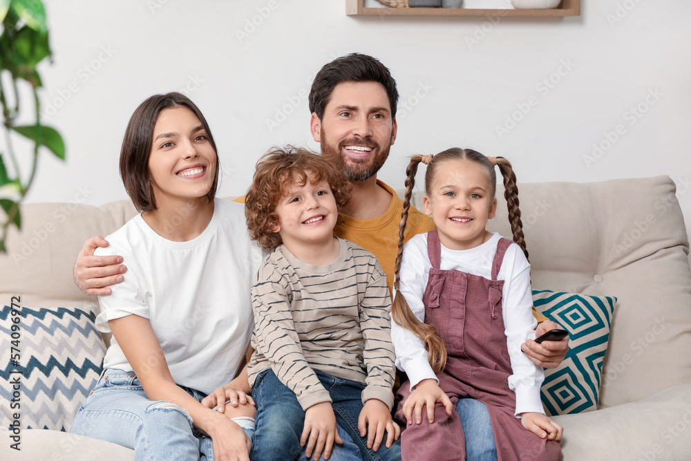 Happy family watching TV on sofa indoors Happy family watching TV on sofa indoors