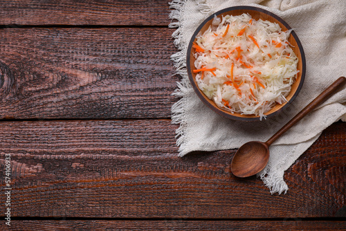 Bowl of tasty sauerkraut on wooden table, flat lay. Space for text