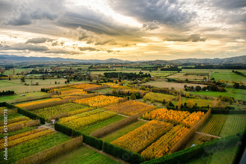 Flying in a helicopter over the rural agricultural countryside in the Wairarapa under a stunning cloudscape