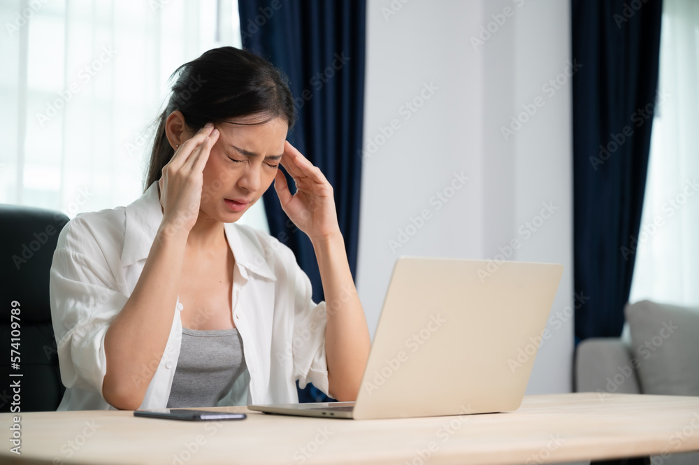 Office syndrome. Overworked tired young asian woman feeling headache, having eyesight problem after computer laptop work. Stressed young woman suffering from fatigue at home Office syndrome. Overworked tired young asian woman feeling headache, having eyesight problem after computer laptop work. Stressed young woman suffering from fatigue at home