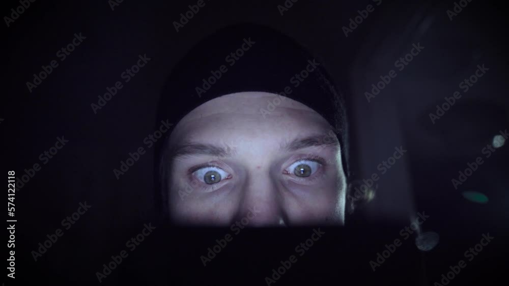 Man obsessed with scrolling in a dark environment. He is wearing a black hat. Man obsessed with scrolling in a dark environment. He is wearing a black hat.