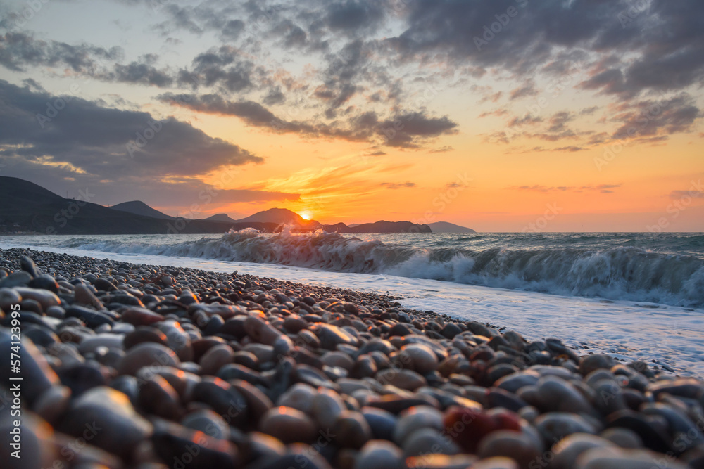 Obraz premium Sea coast with stones at sunrise. Beach of Black sea