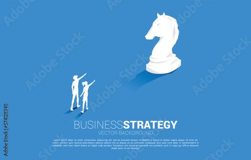 Silhouette of businessman and businesswoman point forward with chess piece. concept of business strategy marketing.