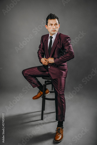 Hombre con traje en estudio con fondo plomo