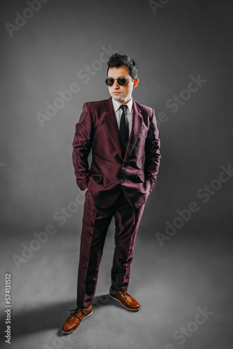 Hombre con traje en estudio con fondo plomo