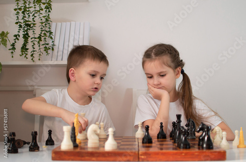 girl is playing chess with her brother at home. Children play board games. Toys for elementary school or kindergarten. Concept of child development. Selective focus