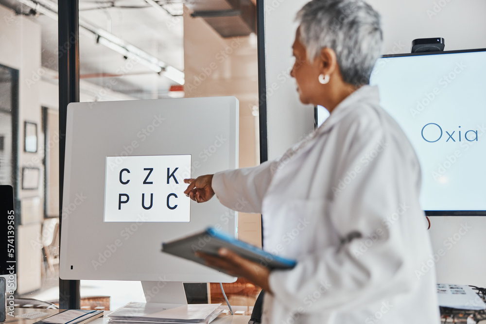 Naklejka premium Letter eye exam, chart and senior woman doctor pointing to eyes test and clinic assessment sign. Consulting, optometrist and tablet of a healthcare employee in a office for wellness and health