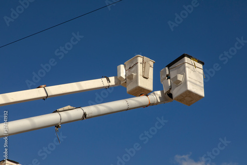 Manlift boom arms for utility work or trtee trimming against a blue sky