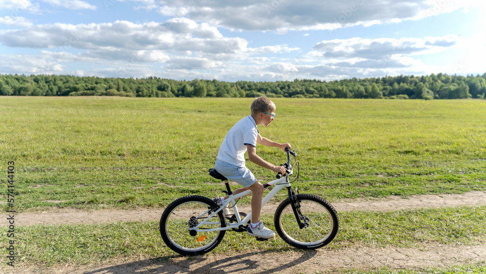 Fototapeta premium loving mother help her cute son ride a bicycle