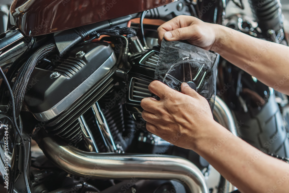Man use a Air Cleaner Rain Sock or Filter Protective Cover Dustproof bag on motorcycle to repel moisture that could damage the filter, maintenance motorcycle concept. Man use a Air Cleaner Rain Sock or Filter Protective Cover Dustproof bag on motorcycle to repel moisture that could damage the filter, maintenance motorcycle concept.