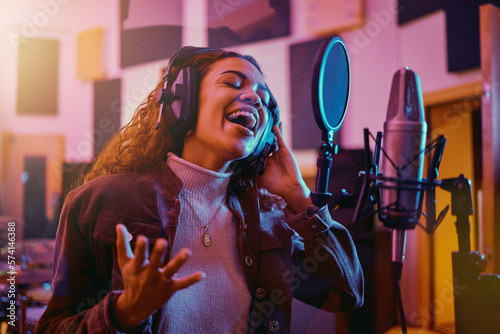 Recording, music and woman singing in a studio for radio, song production and rehearsal. Creative, voice and singer making a record, track or musical sound with a talent as a professional artist photo