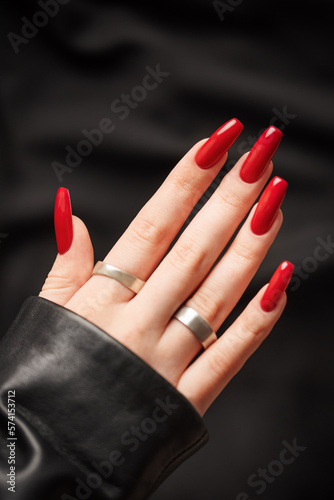 Hands of a young girl with red manicure on nails