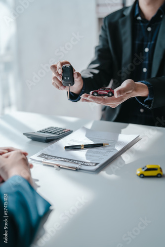 give a car keys, A car dealer or sales manager offers to sell a car and explains the terms of signing a car and insurance contract.