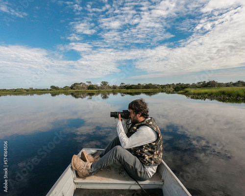 Turista fotografando animais em passeio de barco no no Pantanal de Barão de Melg Fototapeta