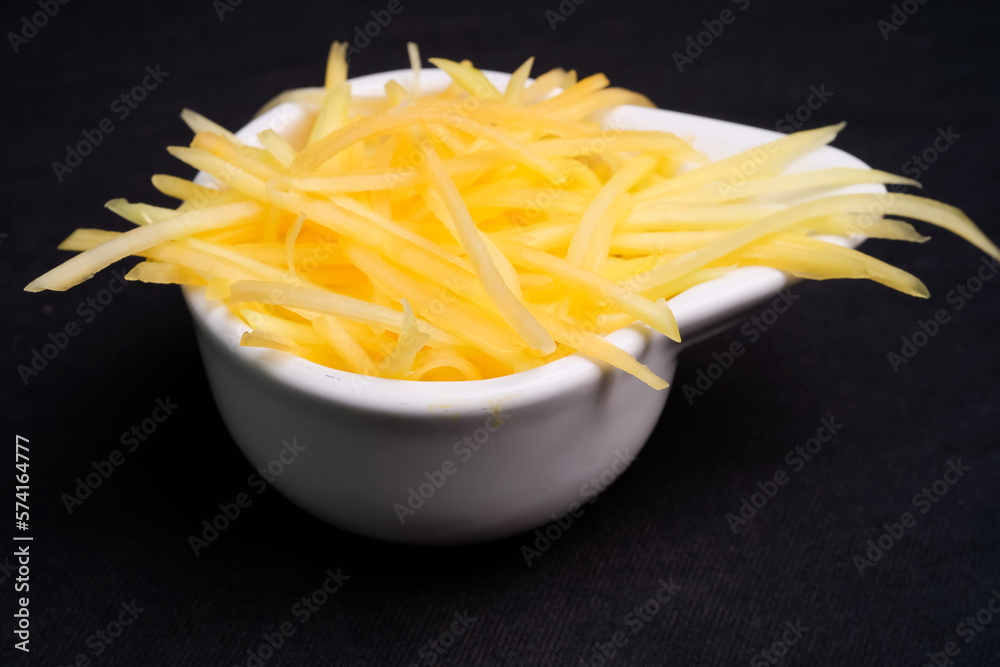 Half-ripe papaya grated in a bowl ready to cook. Raw papaya slices. Half-ripe papaya grated in a bowl ready to cook. Raw papaya slices.