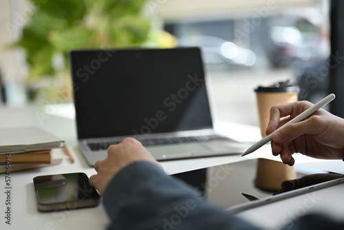 Cropped image of a businessman or male office worker using his digital tablet at his office desk.