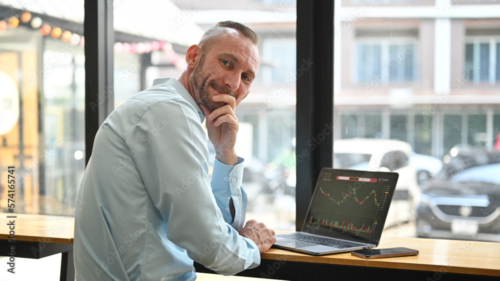 Caucasian businessman trader investor using laptop with financial chart trading online investment data on monitor