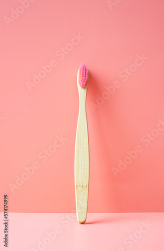 Natural bamboo toothbrush on pink background. Dental care concept