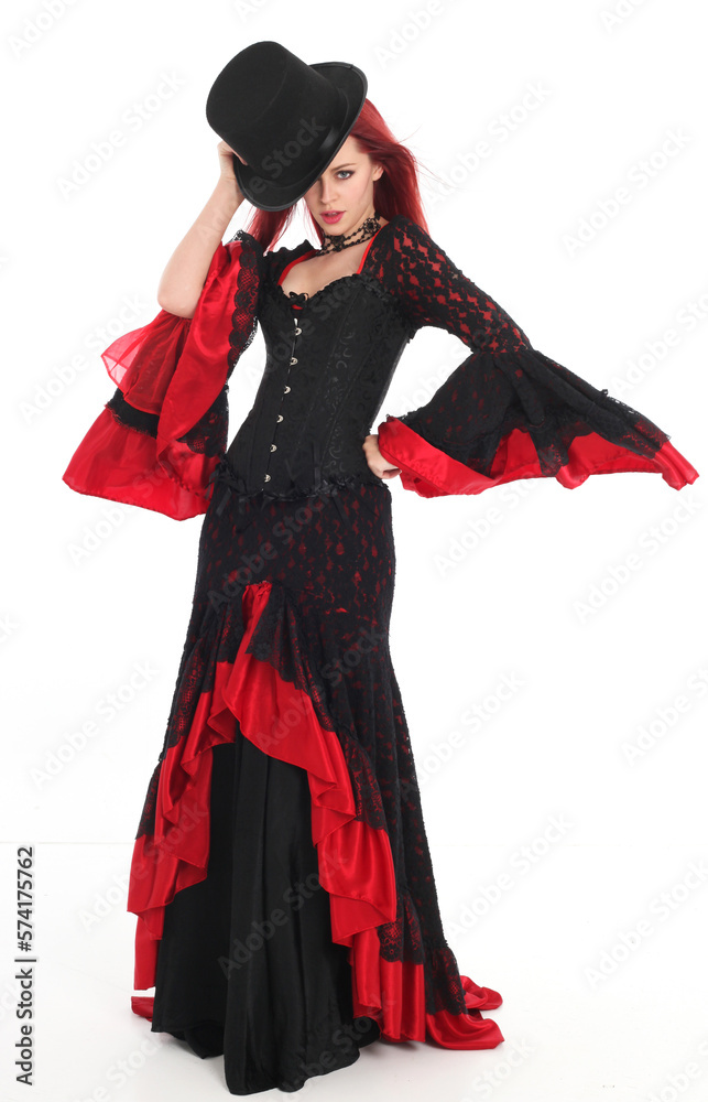 portrait of beautiful red haired woman wearing long black fantasy vampire costume gown, isolated pose on  studio background.