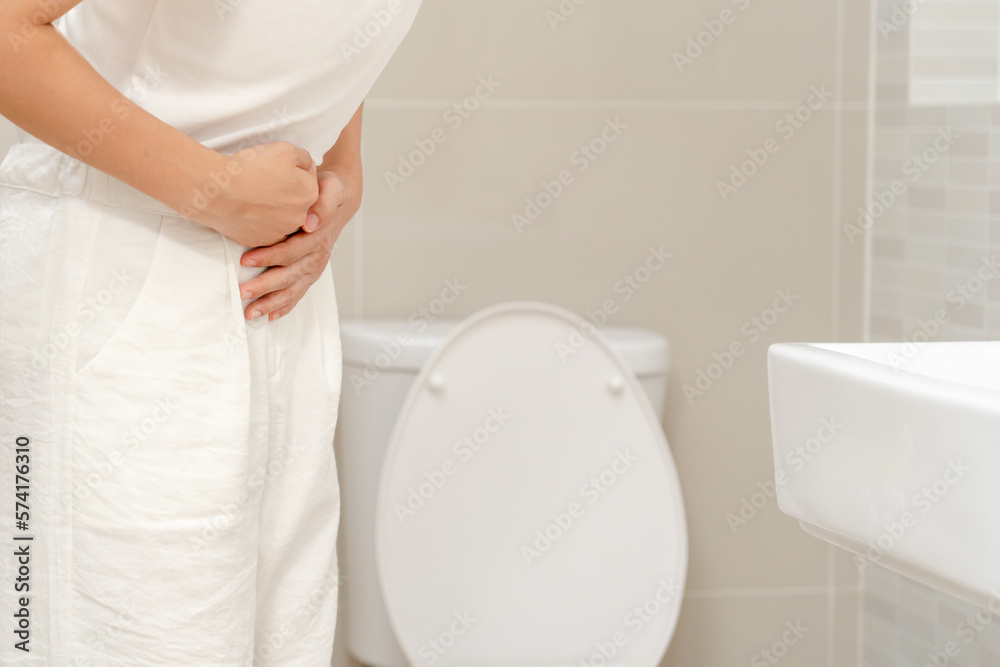 Constipation and diarrhea in bathroom. Hurt woman touch belly stomach ache painful. colon