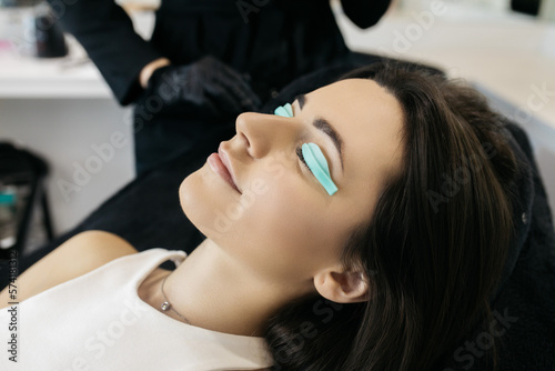 A girl in a beauty salon. A girl is undergoing an eyelash lamination procedure.