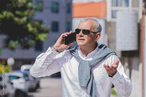 mature man with phone in the street