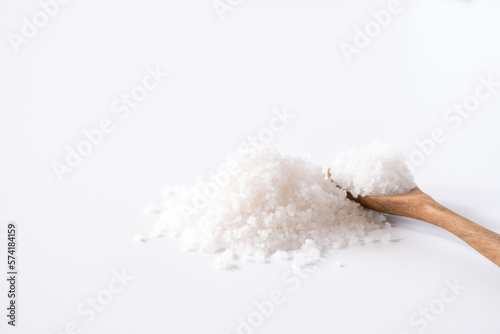 Flower of salt, is a salt that forms as a thin, delicate crust on the surface of seawater in the wooden spoon isolated on white wooden background. Called Fleur de sel in French.