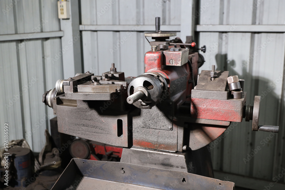 Close up metal lathe machine for polishing car disc brake at garage. Maintenance automotive and inspecting vehicle part concept