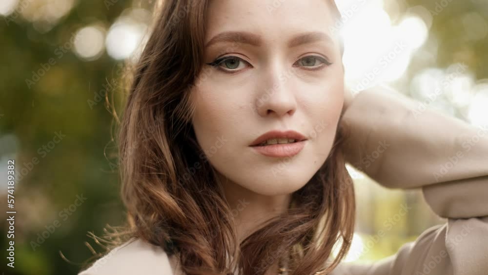 Young beauty touching her beautiful brunette hair and looking at the camera. Happy female models posing outdoor. It looks wonderful and charming. It has a good appearance. Stylish and elegant Young beauty touching her beautiful brunette hair and looking at the camera. Happy female models posing outdoor. It looks wonderful and charming. It has a good appearance. Stylish and elegant
