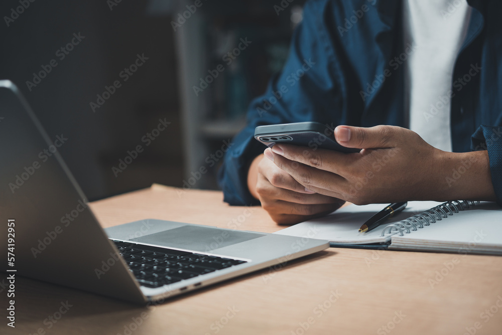 man using mobile smart phone and working on laptop computer.education and technology concept, student working, Freelance. man using mobile smart phone and working on laptop computer.education and technology concept, student working, Freelance.