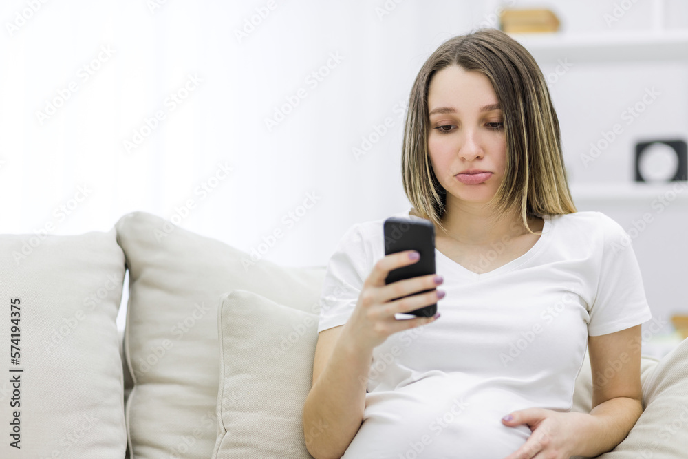 Photo of sad pregnant woman looking in the phone. Photo of sad pregnant woman looking in the phone.