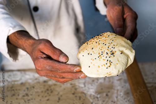 A risen taboon bread or Lafah, a Middle Eastern flatbread, being held by the baker as it has just come out of a tabun oven. photo