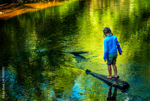 A girl walks on a submerged log near Hiawatha National Forest MI. photo