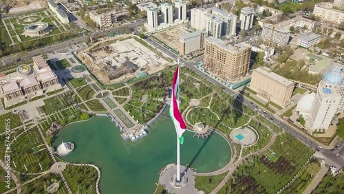 Dushanbe city center landmarks and flag of Tajikistan. Aerial cinematic shot over a Rudaki park and national library. photo