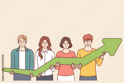 Team of men and women together hold green arrow pointing up, symbolizing development and success business. Concept of growth in financial performance due to teamwork of company employees 