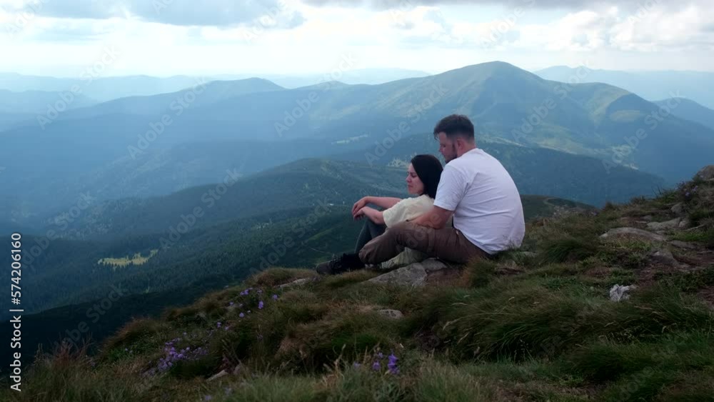 couple hikers resting on the top of Hoverla mount in Ukraine couple hikers resting on the top of Hoverla mount in Ukraine