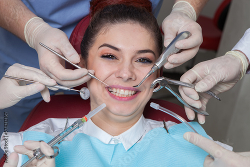 Dentist with assistant and patient at dental clinic. Dentistry. Close-up of a female patient having her teeth examined by dentist